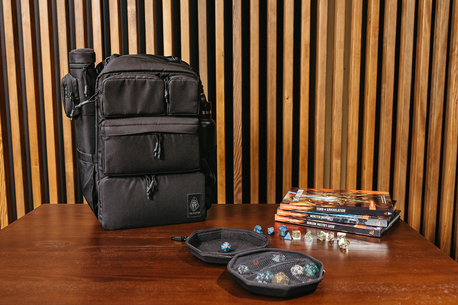 Alkem Gear backpacks, dice, and tabletop accessories arranged together